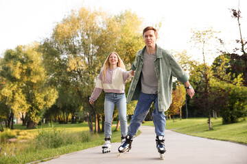 Happy couple roller skating together in park