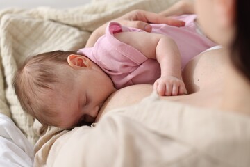 Mother breastfeeding her newborn baby indoors, above view