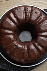 Tasty chocolate bundt cake on wooden table, top view