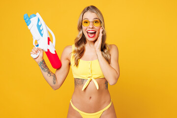 Young excited beautiful sexy woman wear bikini swimsuit sunglasses rest near hotel pool hold in...