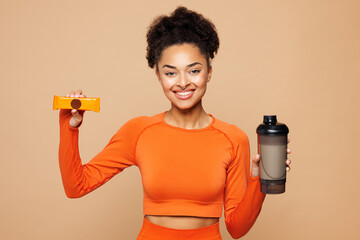 Young fitness trainer instructor woman sportswoman she wear orange clothes spend time in home gym...