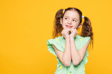 Little toothy kid child girl 8-9 years old wears green t-shirt put hand prop up on chin, lost in...