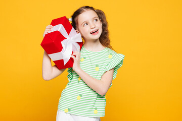 Little minded pensive cheery kid child girl 8-9 years old wears green t-shirt hold red present box...