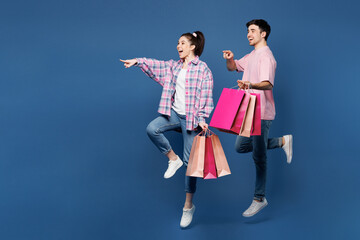 Full body young couple two friends family man woman wear pink casual clothes together hold shopping...