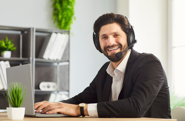 Businessman happy smiling, call service man wearing headset sitting at office desk, typing on...