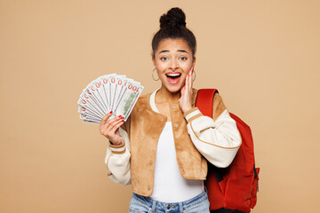 Young shocked girl student wear casual clothes backpack bag hold in hand fan of cash money in...