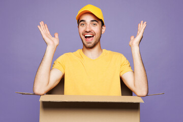 Young shocked delivery guy employee man he wear yellow cap t-shirt uniform workwear work as dealer...