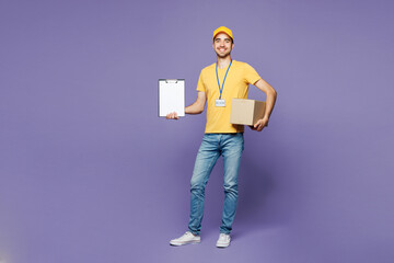 Full body young delivery guy man wears yellow cap t-shirt uniform workwear work as dealer courier...