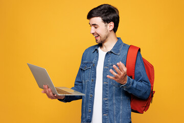 Young boy IT student he wear jeans casual clothes backpack bag hold use work on laptop pc computer...