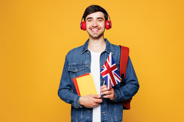 Young boy student wears jeans casual clothes backpack bag hold books British flag listen to music...
