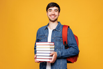 Young smiling happy clever smart boy student he wear denim casual clothes backpack bag read hold...