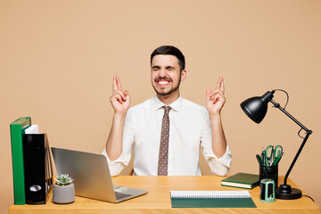 Young employee business man wear white shirt tie sit work at office desk with pc laptop keeping...