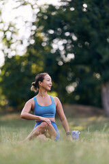 Woman Practicing Yoga Outdoors in Nature Wearing Fitness Clothing in a Park