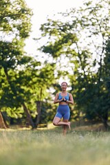 Woman Practicing Yoga Outdoors in Peaceful Forest During Summer Morning
