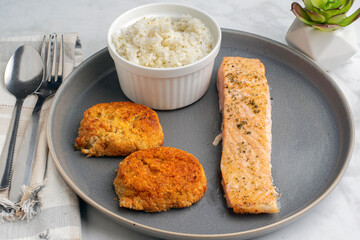 baked salmon served with crab cakes and rice