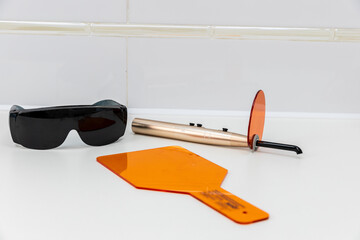 Innovative Dental Equipment Displayed on a Clean Surface: Protective Glasses, Orange Shields, and a...