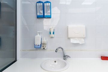 Modern Restroom Setup Featuring Hand Sanitizer and Paper Towel Dispenser in a Light-Colored...