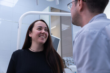 Engaging dental conversation in a modern clinic between a patient and a dentist highlighting professionalism and comfort in dental care, smiling faces reflecting positive experience.