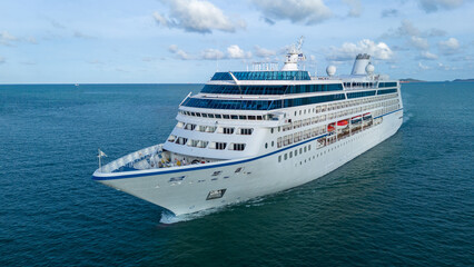 Aerial top view of a luxury cruise ship sailing through deep blue ocean water. Vibrant deck design with pools, sun loungers, and activity zones, ideal for travel, vacation, and maritime lifestyle
