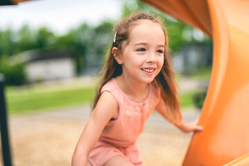 Happy kid slide on playground on summer season