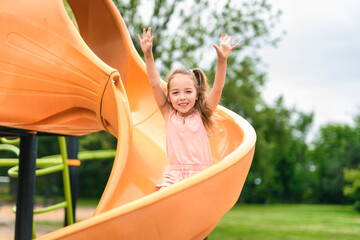 Happy kid slide on playground on summer season