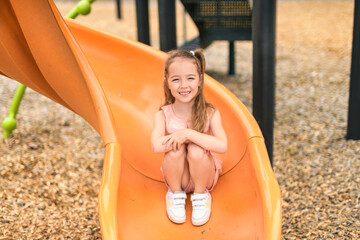 Happy kid slide on playground on summer season
