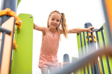 Happy child girl on playground on summer season