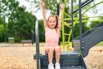 Happy child girl on playground on summer season