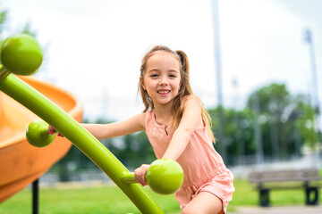 Happy child girl on playground on summer season
