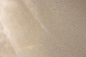 Overlay of natural,transparent sunlight casting soft shadows,smooth blurred transitions of tones and creating abstract holographic shades on a gray beige textured background for advertising,posters.