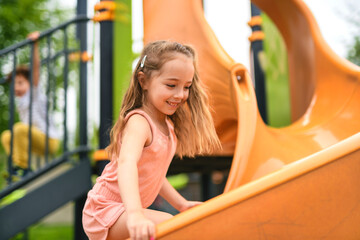 Happy kid slide on playground on summer season