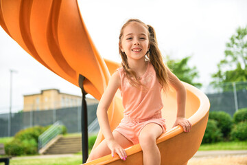 Happy kid slide on playground on summer season