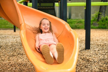 Happy kid slide on playground on summer season