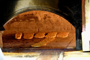 Traditional Turkish Konya meat bread is made in a stone oven. Minced meat bread and pide are baked over a wood fire. The pide chef slides the pide onto the oven with a shovel. Turkish cuisine.