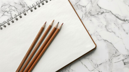 White Sketchbook with Brown Pencils on Marble Desk 
