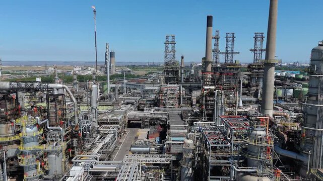 Aerial drone close up view of large industrial Humber petrochemical refinery, fuel storage silos, pipes and pipelines, reactors cooling towers and smoke stacks England UK