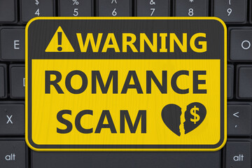 Romance Scam yellow warning sign on a computer keyboard
