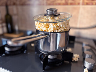 Homemade Fresh Popcorn Overflowing from a Steel Pot on the Stove