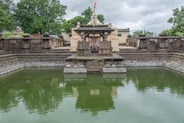 Obraz premium Elegant step-well known as Pushkarni. surrounded by a stone wall with 24 niches devkoshatas, Pushkarni is amplified by the wonderfully carved pavillion, Loni Bhapkar, Morgaon, Maharashtra, India.