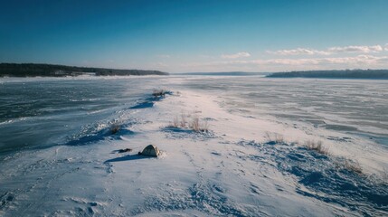 Fototapeta premium Frozen river expanse, snowy shoreline