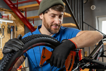 Master fixes bike wheel in organized garage with modern setup