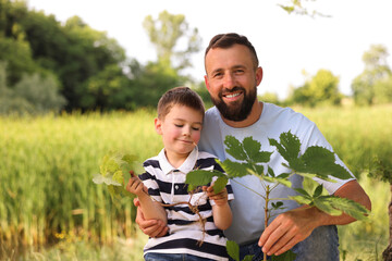 Father and his son planting tree outdoors