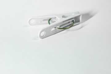 Close-up of a white plastic clothespin against a plain white background.