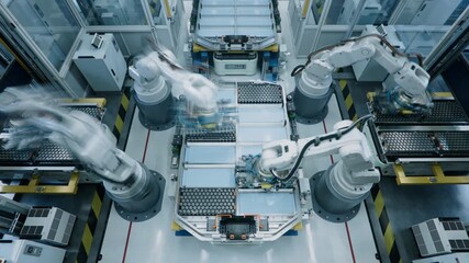Time-Lapse of Industrial Robot Arms Assemble Lithium-Ion EV Battery Pack for Automotive Industry. Top View of Automated Production Line with White Robotic Arms at Factory.  Smart Manufacturing Line - Powered by Adobe
