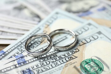 Silver wedding rings and dollar banknotes, closeup