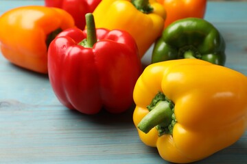 Fresh colorful bell peppers on blue wooden table, closeup
