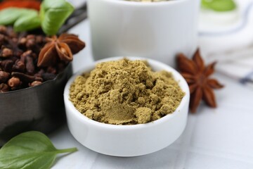 Different aromatic spices on white tiled table, closeup