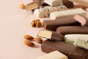Different whey protein bars with various coatings and sprinkles on pink background. Close up. Copy space.