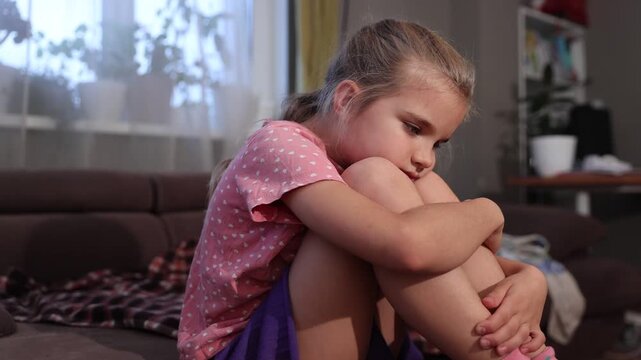 child girl depression. A sad little girl  Sitting on the couch at home. 