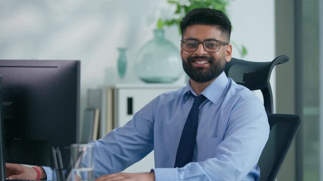 Muslim man Arabian business male worker Indian productive businessman guy working with computer looking at camera smiling happy positive manager online good work at table smile satisfied portrait